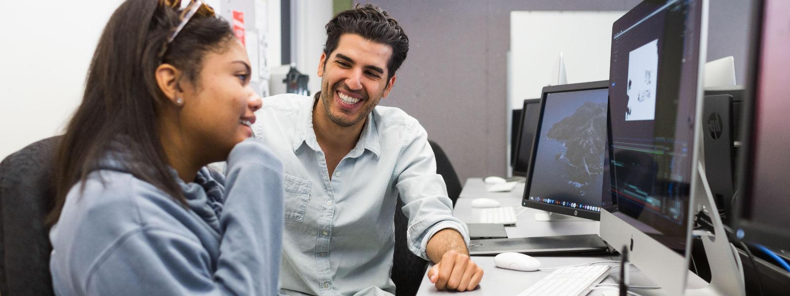 Flipped version of existing image. Instructor and student working together and smiling.