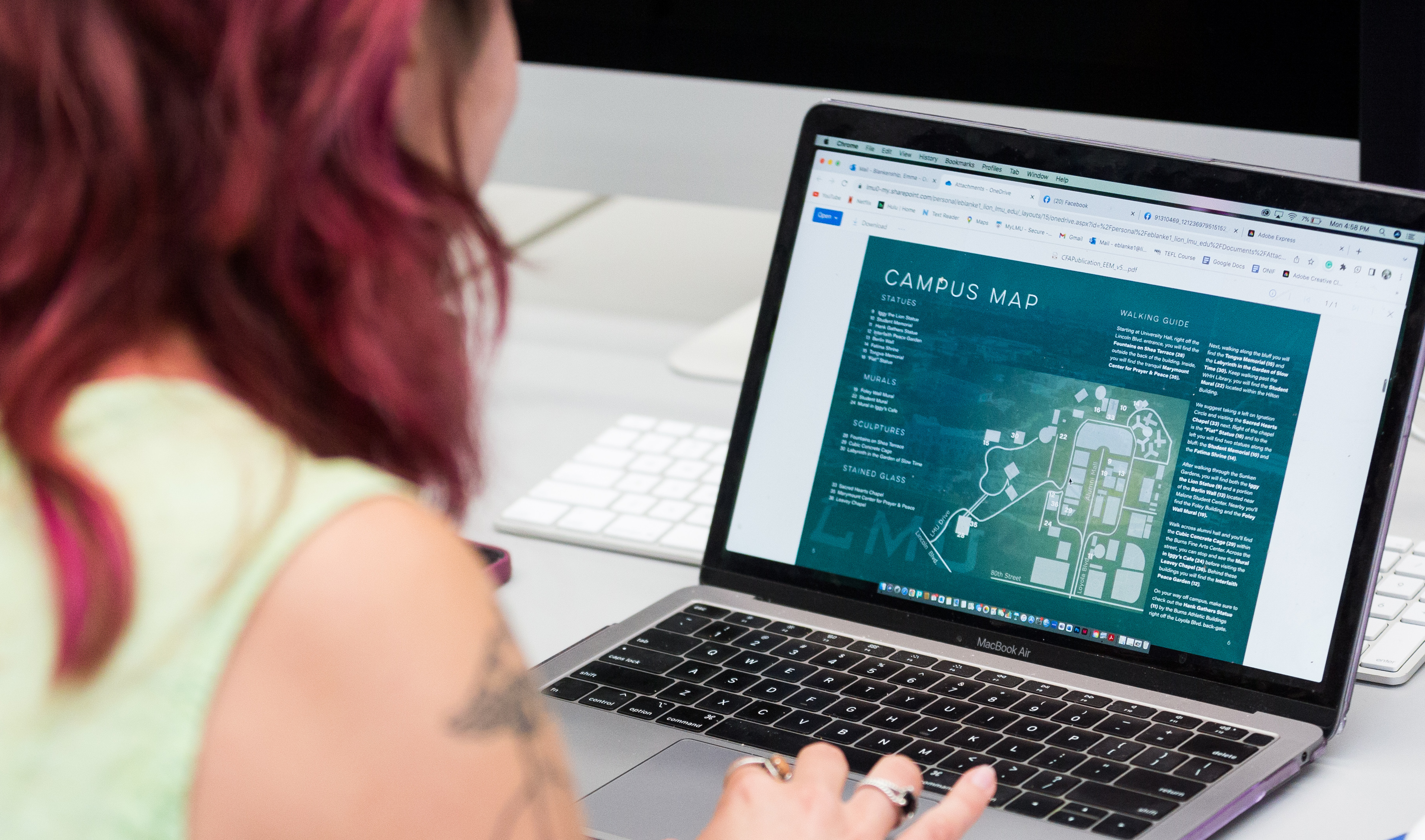 Hero image shows over-shoulder angle of student using laptop computer with 