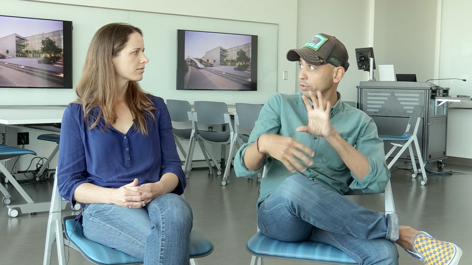Screen grab shot from a video shows two professors sitting beside each other and speaking to each other in a two-subject interview for the video camera