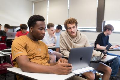 Students in computer science looking at a computer screen